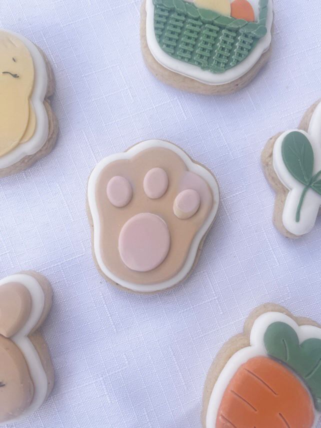 Konijnenpootjes koekjes en een wortelkoekje op een blauwe ondergrond