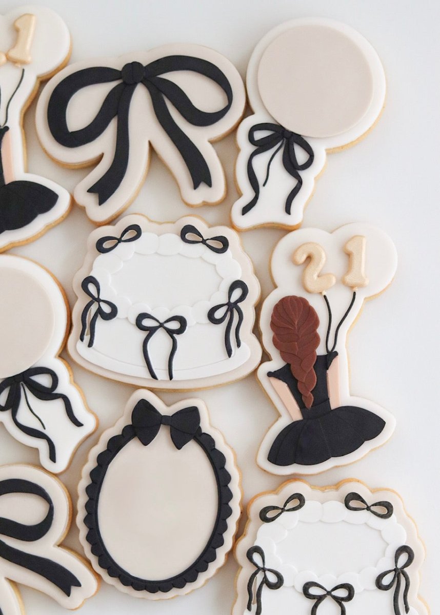 Overzicht van koekjes met zwarte strikjes, ballonnen en ovale kaders