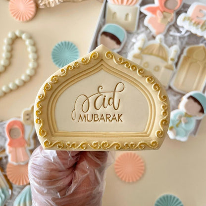 Goudkleurig boogkoekje met Eid Mubarak in de hand