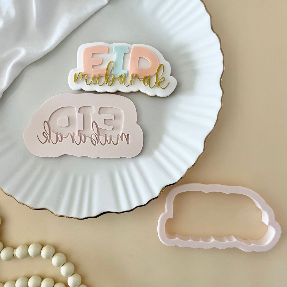Eid Mubarak koekje met stempel en uitsteker op een wit bord