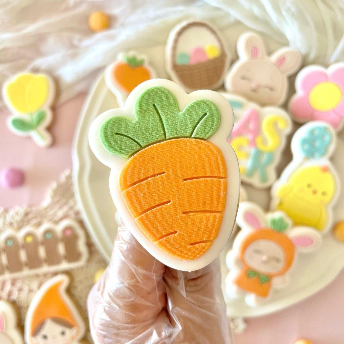 Oranje wortelkoekje met groen loof in de hand