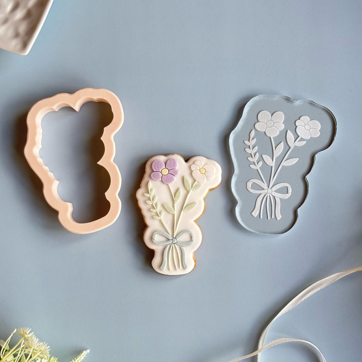 Uitsteker, doorzichtige stempel en bloemboeket koekje naast elkaar