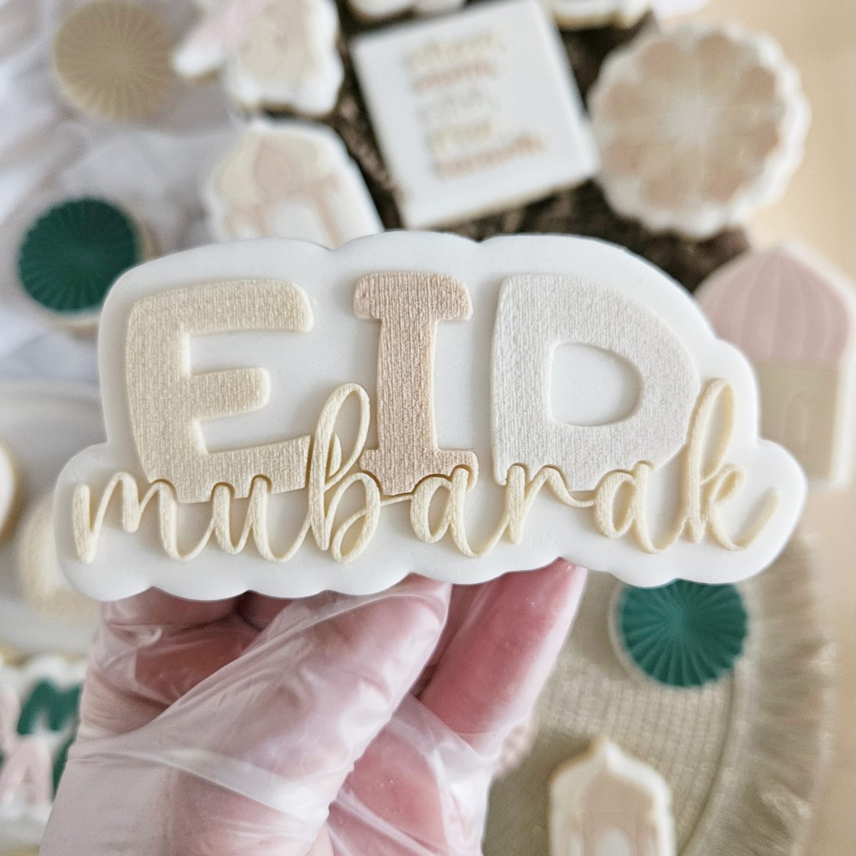 Koekje met EID in grote letters en mubarak in goudkleurige sierletters