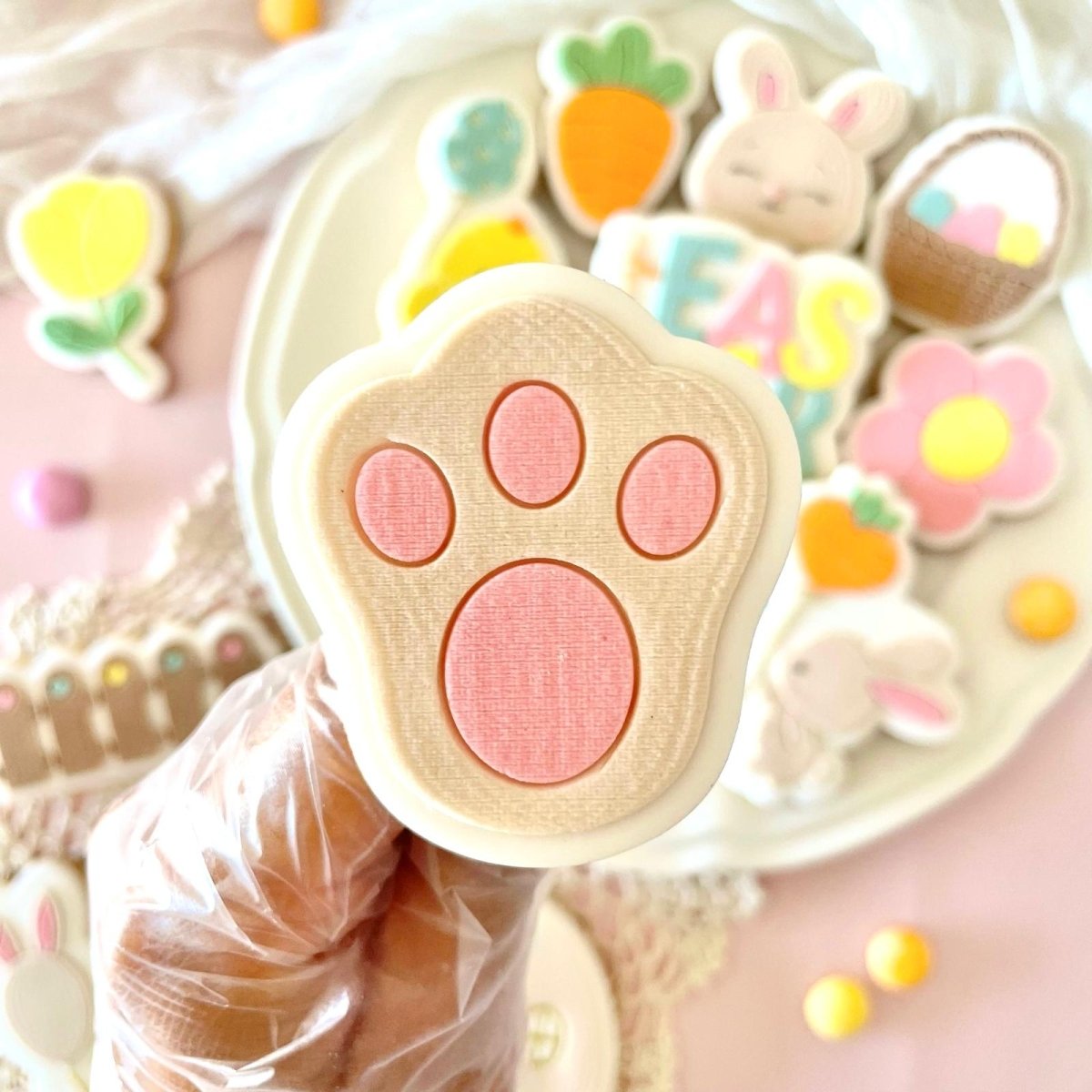 Konijnenpootje koekje met roze kussentjes in de hand