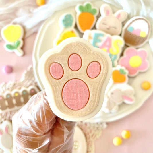 Konijnenpootje koekje met roze kussentjes in de hand