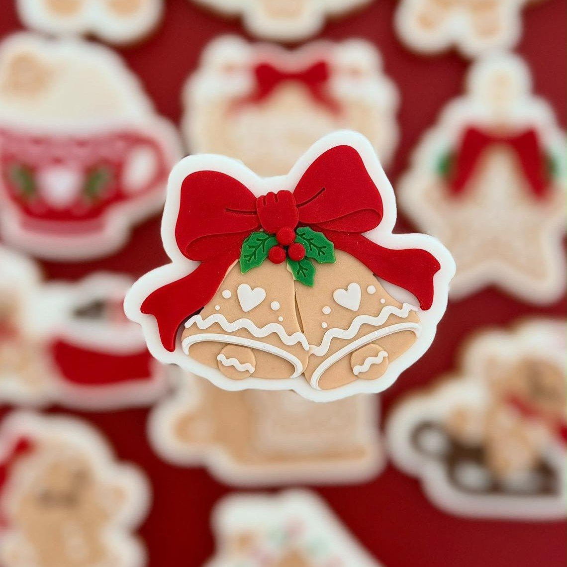 Kerstklokken koekje met rode strik en hulstblaadjes