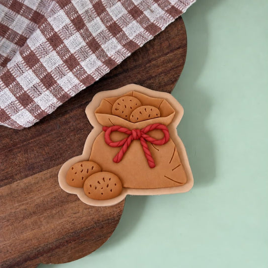 Koekje in de vorm van de zak van Sinterklaas met rood touw en koekjes