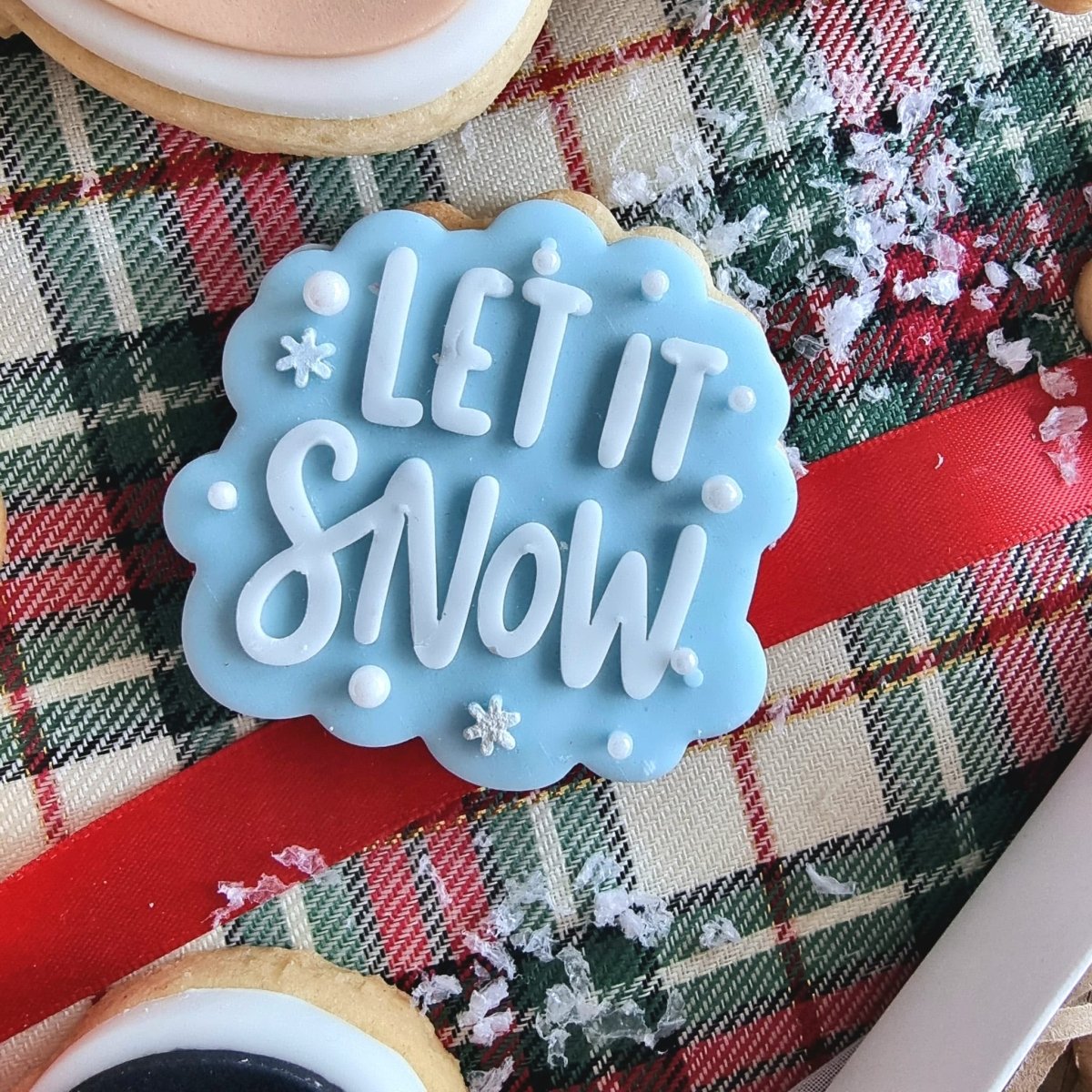 Lichtblauw mini koekje met Let it Snow in witte letters
